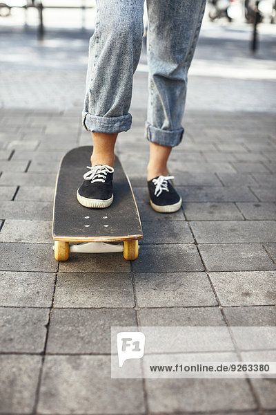 Junge Skateboarderin auf ihrem Skateboard  Teilansicht
