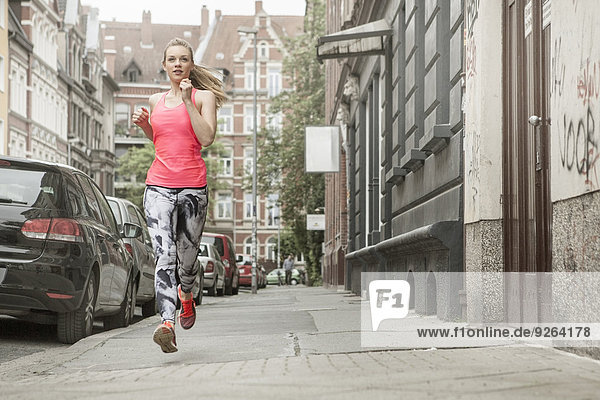 Deutschland Niedersachsen Hannover junge Joggerin auf dem Gehweg