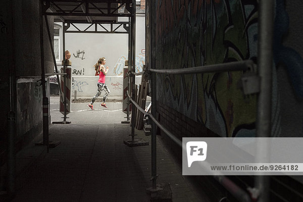 Deutschland  Niedersachsen  Hannover  junge Joggerin beim Laufen auf der Straße