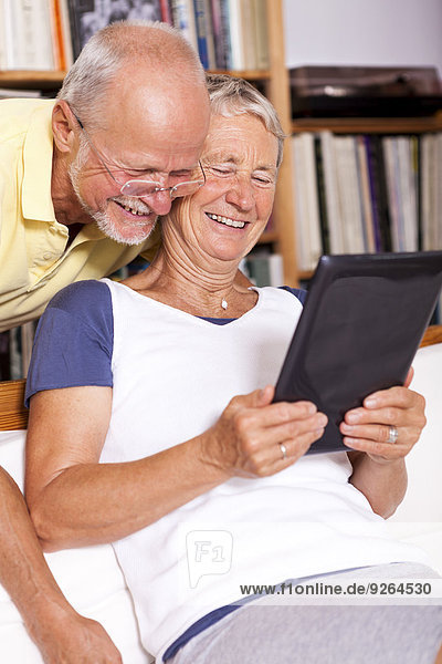 Seniorenpaar zu Hause mit Spaß am digitalen Tablett