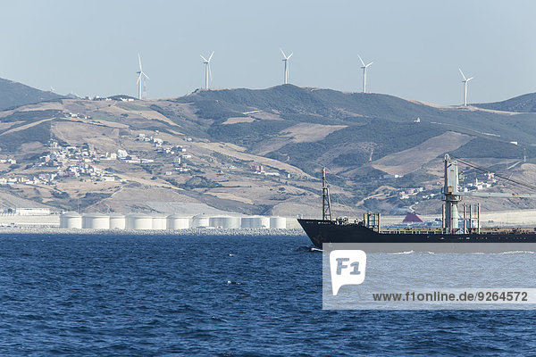 Marokko  Tanger  Straße von Gibraltar  Frachtschiff  Windpark und Raffinerie an der Küste