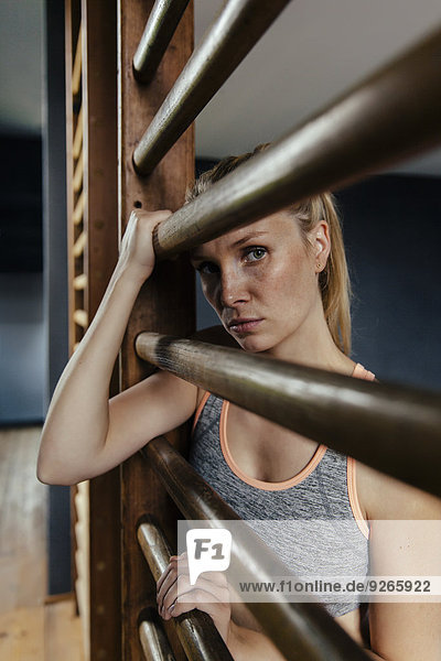 Serious woman at wallbars in gym