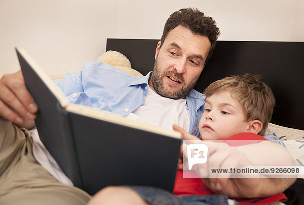 Father and son watching a book together