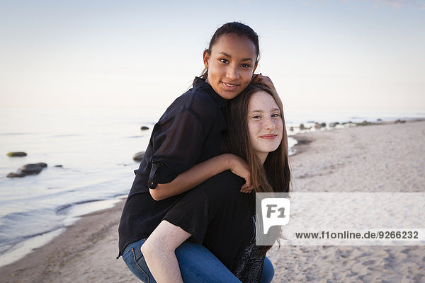 Deutschland  Rügen  Zwei junge Freundinnen am Strand  Huckepack