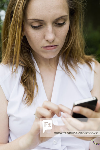Porträt einer jungen Frau mit ihrem Smartphone
