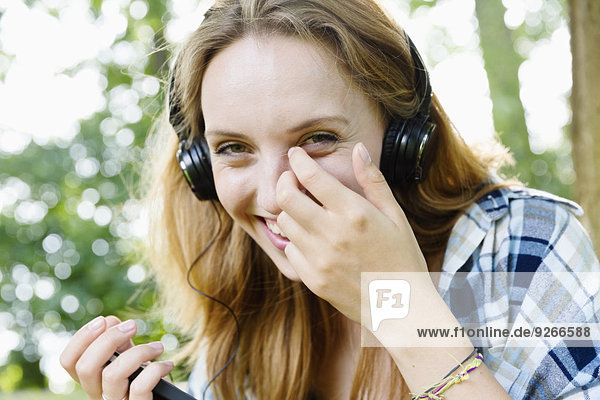Porträt einer lächelnden jungen Frau mit Kopfhörer