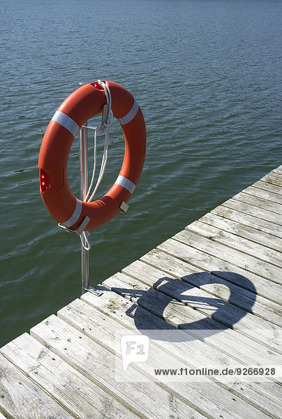 Germany  Brandenburg  part of a jetty and a lifesaver at sunlight