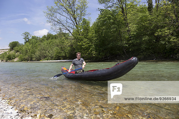 Germany  Bavaria  man paddling in rafting boat on Isar River