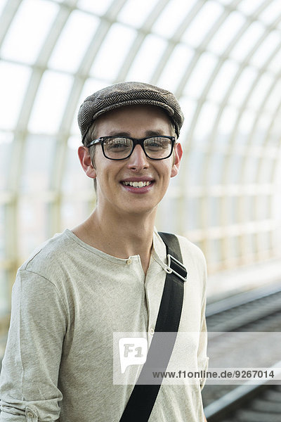 Portrait of young man at commuter train station