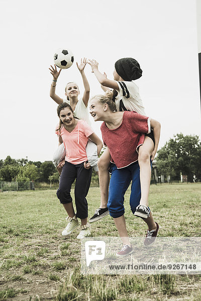 Vier Teenager-Mädchen haben Spaß auf einem Fußballfeld