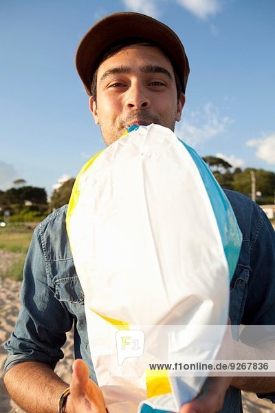 Junger Mann beim Sprengen des Strandballs am Bournemouth Beach  Dorset  UK