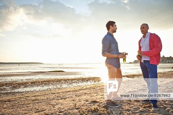 Männer trinken Bier und plaudern am Strand