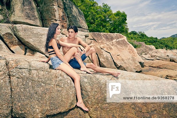 Young couple sitting together on rocks