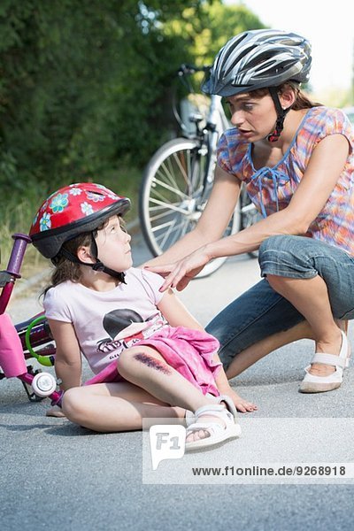 Mutter kümmert sich um Tochter vom Fahrrad gefallen