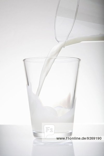 Frische Milch aus dem Krug in das Trinkglas