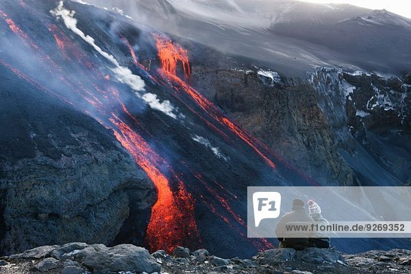 Couple watching volcanic lava  Fimmvorduhals  Iceland
