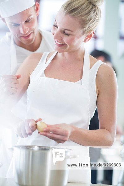 Chef and colleague peeling potatoes in commercial kitchen