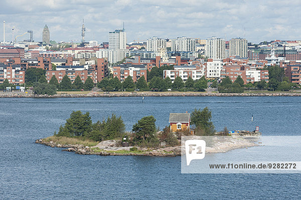 Small island Katajanokanluoto with a wooden cottage skyline of Helsinki at the back Helsinki Finland