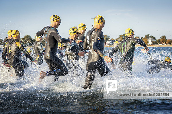 Teilnehmer eines Ironman Triathlons starten das Rennen in der Brandung Amager Strandpark Kopenhagen Dänemark