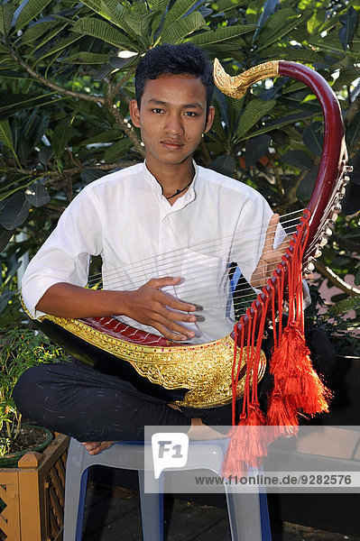Burmese man playing the Saung Gauk  Burmese harp or arched harp  national instrument of Myanmar  Bagan  Mandalay Region  Myanmar