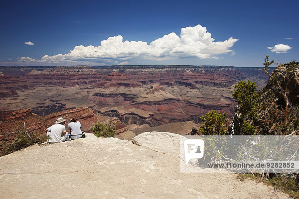 Zwei Touristen sitzen am South Rim des Grand Canyon  Arizona  USA