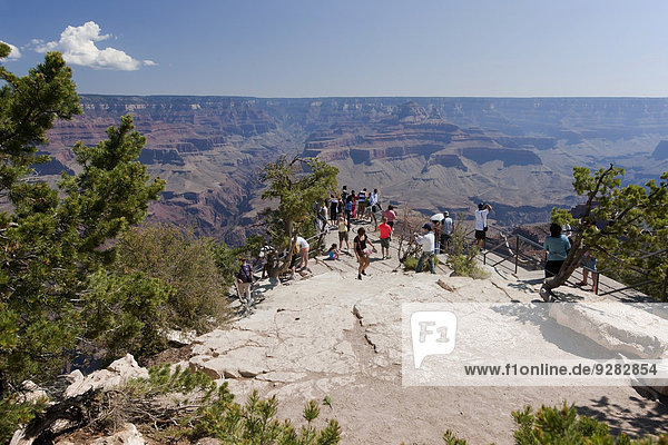 Group of tourists enjoy the view from the South Rim of Grand Canyon  Arizona  USA