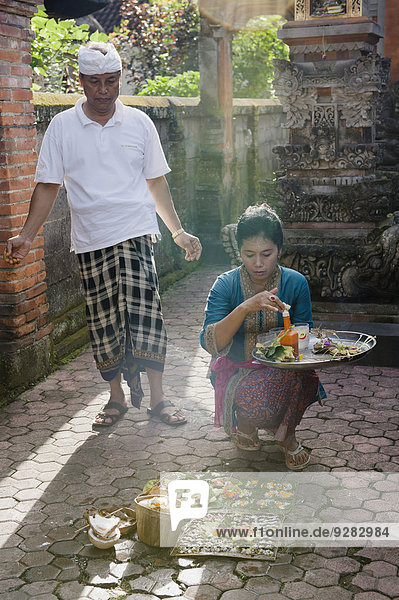 A woman during the daily ceremony of sacrificial offerings in front of a house  Ubud  Bali  Indonesia