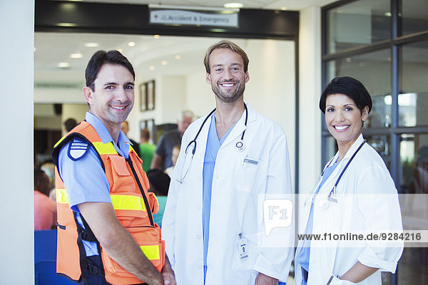 Doctors and paramedic smiling outside hospital
