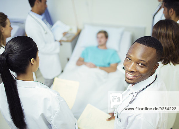 Arzt steht mit Bewohnern im Krankenhauszimmer