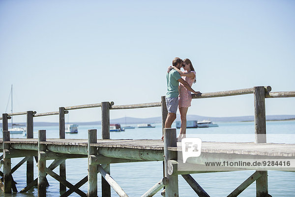 Couple hugging on wooden dock