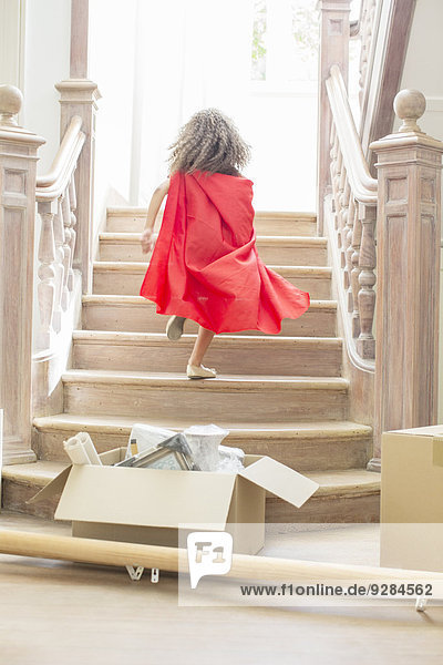 Young girl running up stairs playing