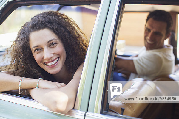Woman relaxing on car door during car ride