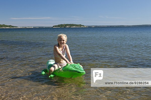 Girl on sea on inflatable crocodile  Ingaro  Sweden