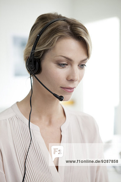 Büroangestellter mit Telefon-Headset-Multitasking