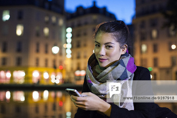 Junge Frau im Freien mit Smartphone  Portrait