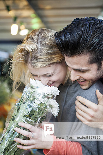 Mann erfreut Girlfiend mit Überraschungsgeschenk von Blumen
