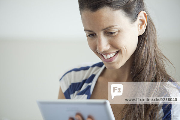 Frau mit digitalem Tablett  lächelnd