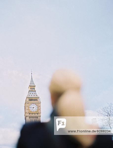 Eine Frau schaut zum Big Ben  dem Elizabeth-Tower im Houses of Parliament in London  auf.