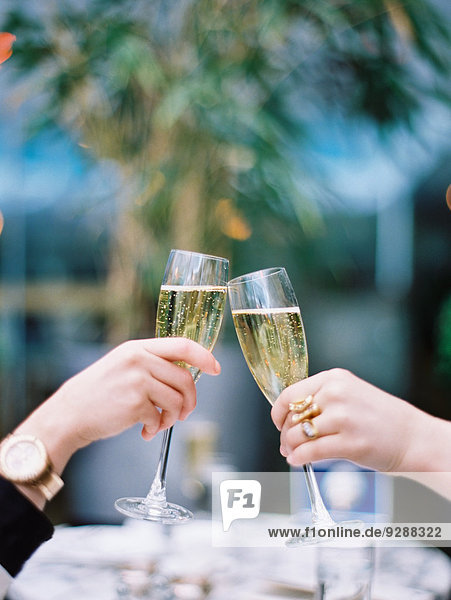 Zwei Frauen stoßen mit Champagnergläsern aufeinander an.