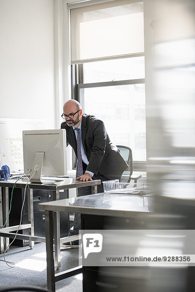 Büroalltag. Ein Mann  der allein in einem Büro arbeitet.