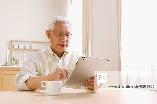 Senior adult Japanese man with tablet