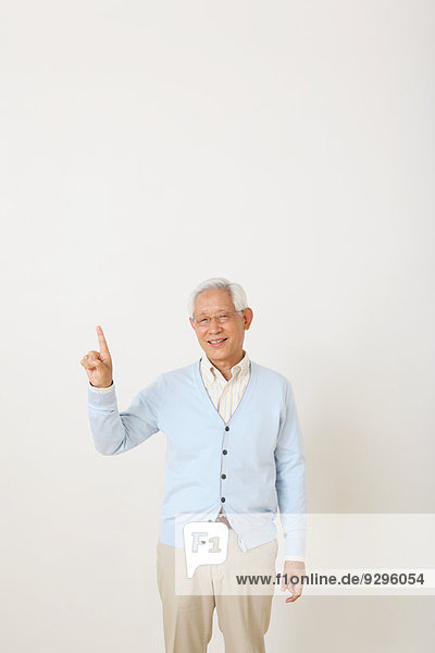 Senior adult Japanese man against white wall