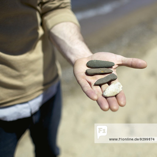 Detail eines Mannes mit Steinen in der Hand