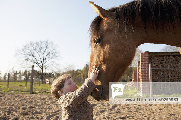 Baby Mädchen streichelndes Pferd