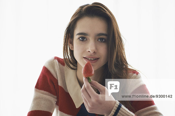 Porträt eines Mädchens mit Erdbeere auf weißem Hintergrund