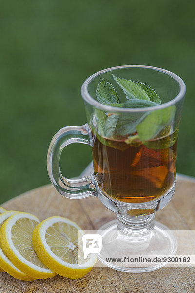 Eistee mit Minze durch Limettenscheiben auf dem Außentisch