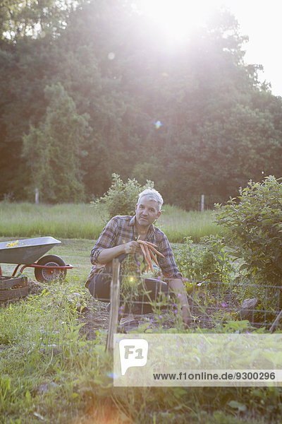 Portrait of mature man working in vegetable garden