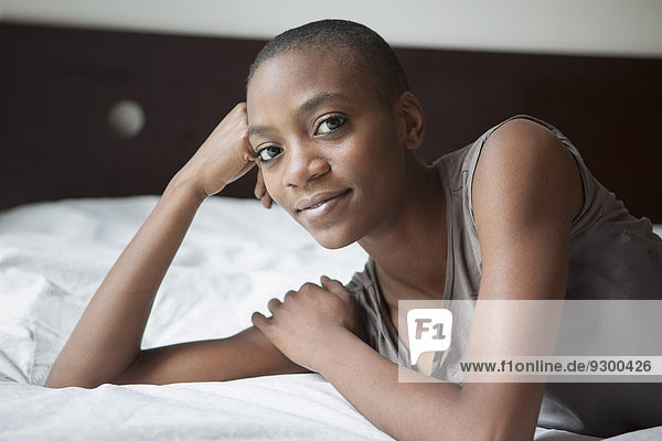 Porträt einer jungen Frau  die zu Hause im Bett liegt.