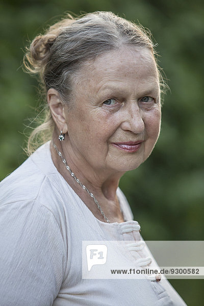 Side view portrait of senior woman smiling outdoors