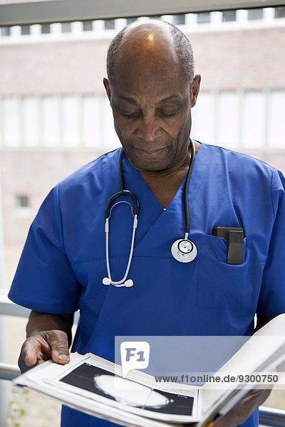 Porträt eines Arztes in Peelings bei der Durchsicht einer medizinischen Akte